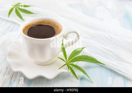 Heißen Kaffee und Marihuana Blätter auf einem Tisch Stockfoto