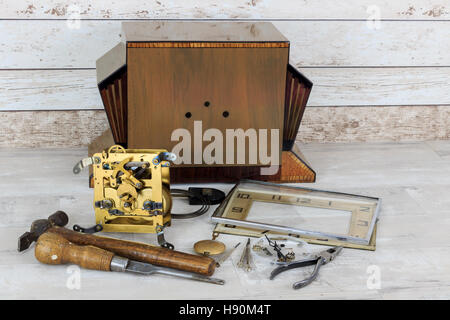 Vintage Jugendstil Holz Kaminuhr in Stücken mit Werkzeugen mit alten schäbigen Holz Wand Effekt Hintergrund Stockfoto