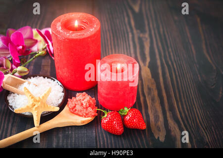 Erdbeer-Körperpeeling mit braunem Zucker und Salz auf den hölzernen Hintergrund Stockfoto