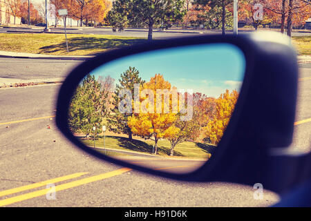 Vintage getönten Foto Herbst Bäume spiegelt sich in dem Auto Außenspiegel, konzentrieren sich auf Bäume, Reise-Konzept Stockfoto