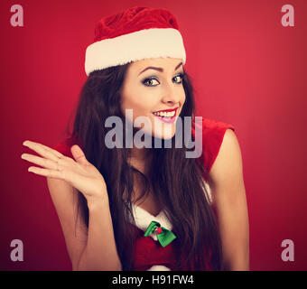 Verwirrt glücklich emotionale Frau auf der Suche im Weihnachtskostüm auf leere Kopie Raum roten Hintergrund. CLoseup portrait Stockfoto