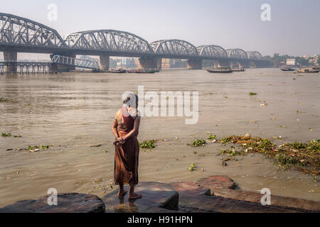 Eine alte Frau Uhren Flut Wasser-Strömung im Fluss Ganges bei Dakshineshwar. Stockfoto