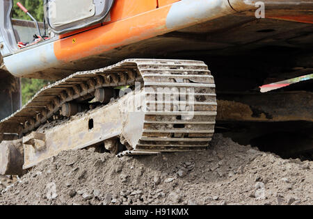 schwere orange Kettenbagger steht auf der Baustelle der Reparatur und den Ausbau die Straße. Stockfoto