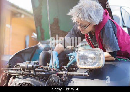 Ältere Kfz-Mechaniker arbeitet an ihrem Oldtimer Stockfoto