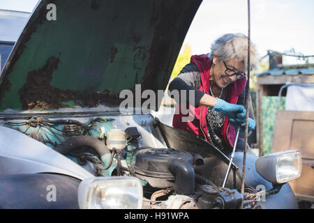Ältere Kfz-Mechaniker arbeitet an ihrem Oldtimer Stockfoto