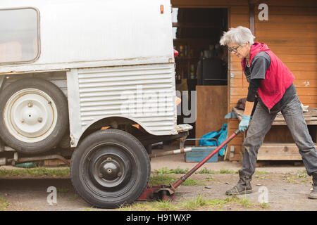 Ältere Automechaniker Aufbocken Oldtimer Stockfoto