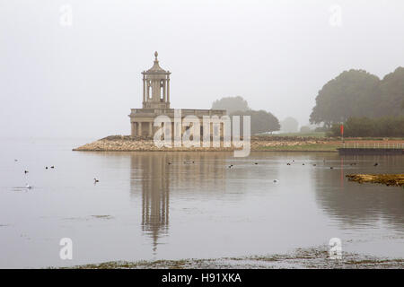 Normanton Kirche im Nebel mit Spiegelbild im Wasser. Rutland Reservoir, Rutland, UK. Stockfoto