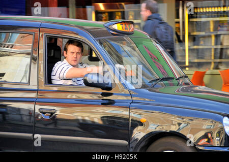 Mann bei der Arbeit als Londoner Taxifahrer in schwarzen arbeiten in der Londoner City Taxi fahren Stockfoto