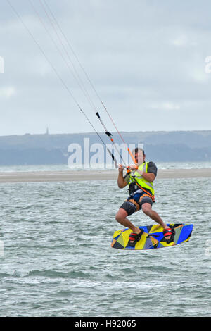 Aktion Mensch Kite Surf Board akrobatischen Sprung Trick vor der Küste von Hayling Island Hampshire England UK beliebte Kitesurfen Wasser Sport Stunt  Stockfoto