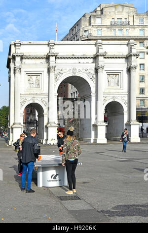 Tischtennis-Ping-Pong Tisch Touristen Rollenspiel auf Gartentisch vor Triumphbogen Marble Arch in London Westend England UK Stockfoto