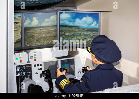 Japan, Nishinomiya, KidZania, untergeordnete Aktivität spielen. ANA Flight Simulator, mit Kind, Junge in Uniform, Holding steuert, während die Pilotierung der Ebene Stockfoto