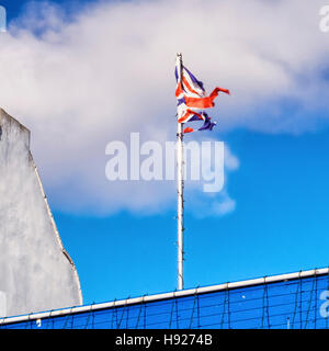 Alt und zerrissene Union Jack-Flagge, Wolken, blauer Himmel. Southend-on-Sea, Essex, England Stockfoto