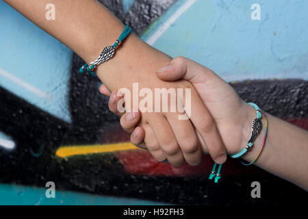 Zwei Hände Freunde gefangen auf einem Hintergrund mit Graffiti bemalt. Stockfoto