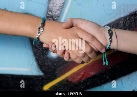 Zwei Hände Freunde gefangen auf einem Hintergrund mit Graffiti bemalt. Stockfoto