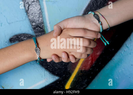 Zwei Hände Freunde gefangen auf einem Hintergrund mit Graffiti bemalt. Stockfoto