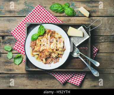 Tagliatelle Bolognese mit Parmesan und Basilikum in Holztablett Stockfoto