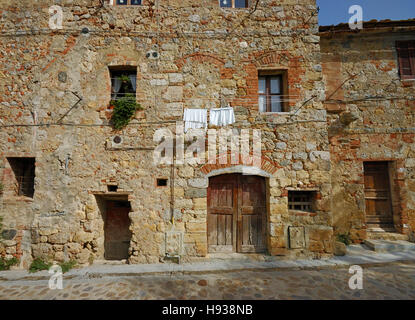 Altes Steinhaus auf einem Stein Straße in der alten ummauerten Stadt Monteriggioni, Toskana, Italien Stockfoto