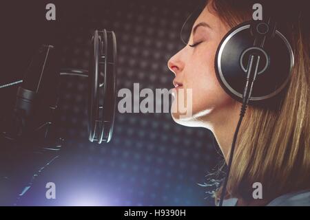 Leidenschaftliche Sängerin und dem Mikrofon. Junge kaukasischen Sängerin in ihren 20ern Album in der professionellen Studio aufzunehmen. Singen mit Leidenschaft. Stockfoto