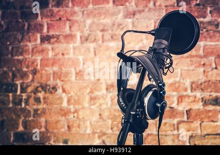 Audio-Aufnahmegeräten auf dem Brick Wall Hintergrund. Professionelles Mikrofon und Kopfhörer. Stockfoto