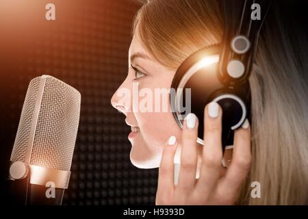 Weibliche Stimmtalent im Tonstudio. Mädchen, die Aufnahme von Voice-Over für Radio-Werbespot. Junges Mädchen in ihren 20ern und das glänzende Metall Pro Mikrofon. Stockfoto