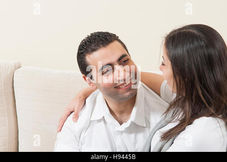 Glückliches Paar zusammen auf dem Sofa sitzen Stockfoto