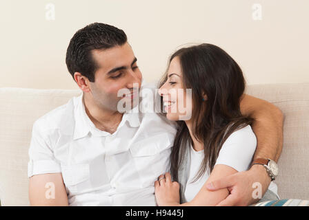 Glückliches Paar zusammen auf dem Sofa sitzen Stockfoto