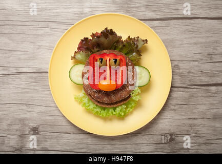 Wütendes Gesicht gemacht von Brot und Gemüse auf Teller Stockfoto