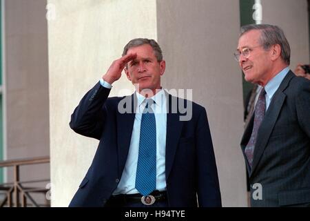 US-Präsident George W. Bush begrüßt wie er das Pentagon mit US-Verteidigungsminister Donald Rumsfeld 12. September 2001 in Washington, DC verlässt. Stockfoto