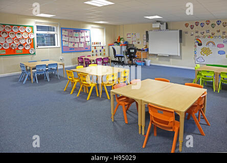 Innenansicht einer modernen Jahr 1 Schulklasse mit Tischen, Stühlen und Kunstwerke an Wänden in leuchtenden Farben Stockfoto