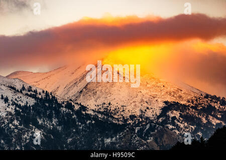 Landschaft von Winter-Berg bei Sonnenauf- oder Sonnenuntergang mit goldene Lichtstrahlen der Sonne am Berg in Griechenland, die ähnlich wie einen Vulkan Stockfoto
