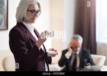 Hocherfreut Geschäftsfrau Kaffeetrinken im Büro Stockfoto