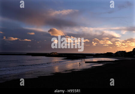 Lyme Regis Dorset, UK. 18. November 2016. Hund Spaziergänger am Strand genießen Sie den wunderschönen Sonnenuntergang bei Lyme Regis in Dorset heute Abend Credit: Simon Dack/Alamy Live News Stockfoto