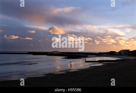 Lyme Regis Dorset, UK. 18. November 2016. Hund Spaziergänger am Strand genießen Sie den wunderschönen Sonnenuntergang bei Lyme Regis in Dorset heute Abend Credit: Simon Dack/Alamy Live News Stockfoto