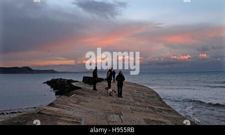 Lyme Regis Dorset, UK. 18. November 2016. Wanderer auf dem Cobb genießen Sie den wunderschönen Sonnenuntergang bei Lyme Regis in Dorset heute Abend Credit: Simon Dack/Alamy Live News Stockfoto