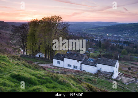 Blick auf Sonnenuntergang von Ilkley Moor des weißen Wells Spa-Cottage (Vordergrund) mit der Stadt im Tal - West Yorkshire, England. Stockfoto