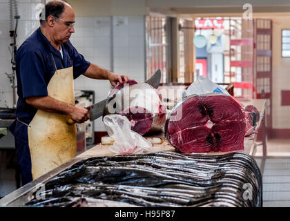 Arbeiter in der Fischmarkt zerschneiden ein riesiger Thunfisch mit einem riesigen Messer Stockfoto