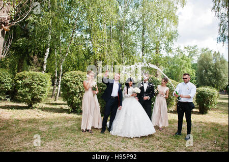 Stilvolle Hochzeitspaar, Brautführer und Brautjungfern mit Champagner Explosion. Stockfoto