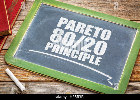 Pareto-Prinzip oder die 80-20 Regel - weiße Kreide Text auf einer Vintage Tafel-Tafel mit Büchern Stockfoto