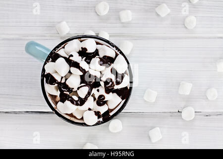 Draufsicht auf eine Tasse heiße Schokolade mit Marshmallows beträufelt mit Schokosauce. Stockfoto