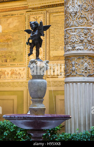 Putto mit Delphin (Andrea Verrocchio), Palazzo Vecchio Innenhof in der Nähe einer dekorierten Spalte. Florenz, Italien Stockfoto