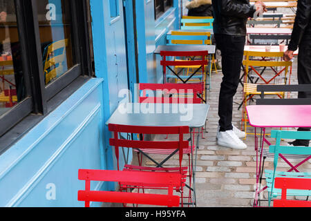 bunte Tische und Stühle von einem Straßencafé in Paris, Frankreich Stockfoto