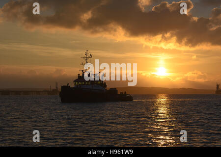 Tug Boat in ruhige See bei Sonnenuntergang warten Milford Haven dock eingeben Stockfoto