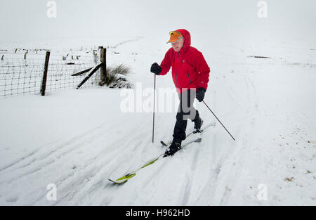 Ein Mann auf Langlauf-Ski in der Nähe der Buttertubs-Pass in den Yorkshire Dales National Park nach Winterwetter Schnee auf einer Anhöhe im Norden von England gebracht. Stockfoto