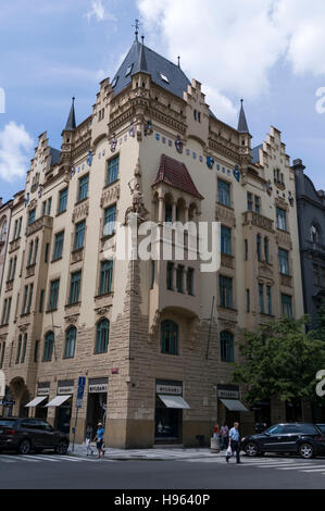 Ein hohes gotisches Gebäude mit einer Reihe von verzierten Schilden an den Wänden hoch über der Pařížská-Straße in der exklusivsten Prager Straße Stockfoto