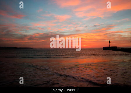 Sunrise-Reflexionen über East Looe Beach und Banjo Pier als die Flut geht aus Stockfoto