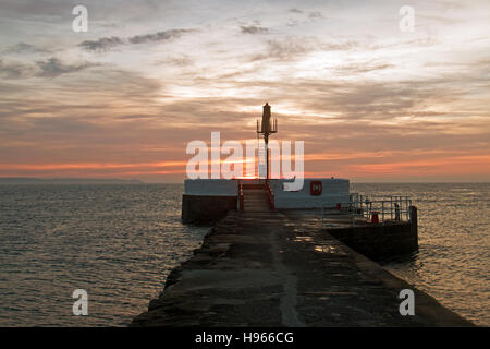 Sunrise-Reflexionen über East Looe Beach und Banjo Pier als die Flut geht aus Stockfoto