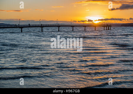 Die Sonne geht hinter dem Fishing Pier in Des Moines, Washington. Stockfoto