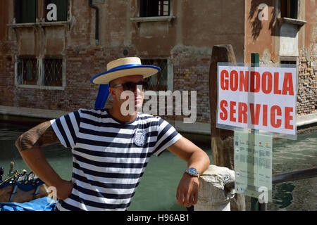 Gondoliere mit der typischen Kopfbedeckung auf einen Kanal von Venedig in Italien. Stockfoto