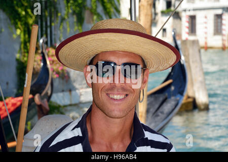 Gondoliere mit der typischen Kopfbedeckung auf einen Kanal von Venedig in Italien. Stockfoto