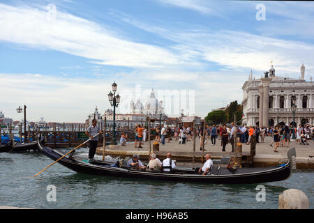 Gondoliere mit Touristen vor der Basilika von Santa Maria della Salute von Venedig in Venedig. Stockfoto